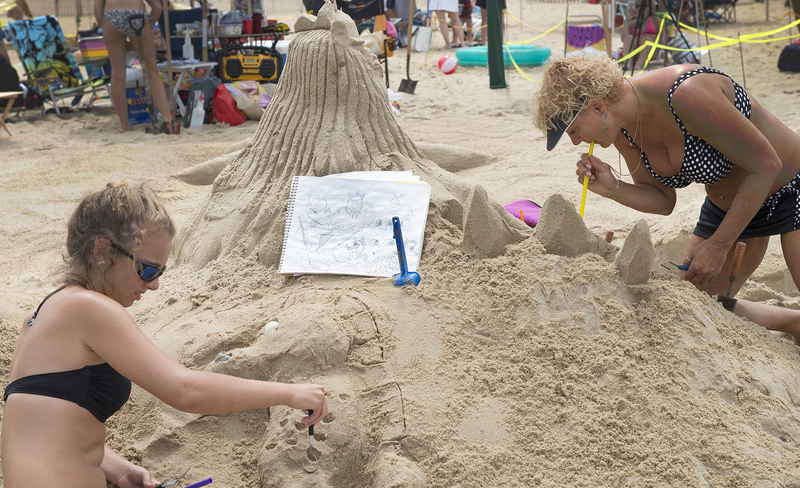 Cheyenne Peet and Sheri Miller, lead designer, use a sketch to get the details right on King Triton's Realm. BY DENY HOWETH